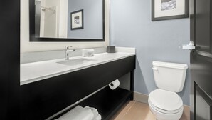 Ein modernes Badezimmer mit schwarzem Waschtisch, weißem Waschbecken und Toilette.
