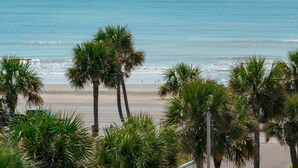 A beach with palm trees and a view of the ocean. - Hyatt Select Galveston - Beachfront (Galveston)