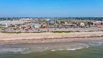 A coastal cityscape with a beach, buildings, and a clear sky.
