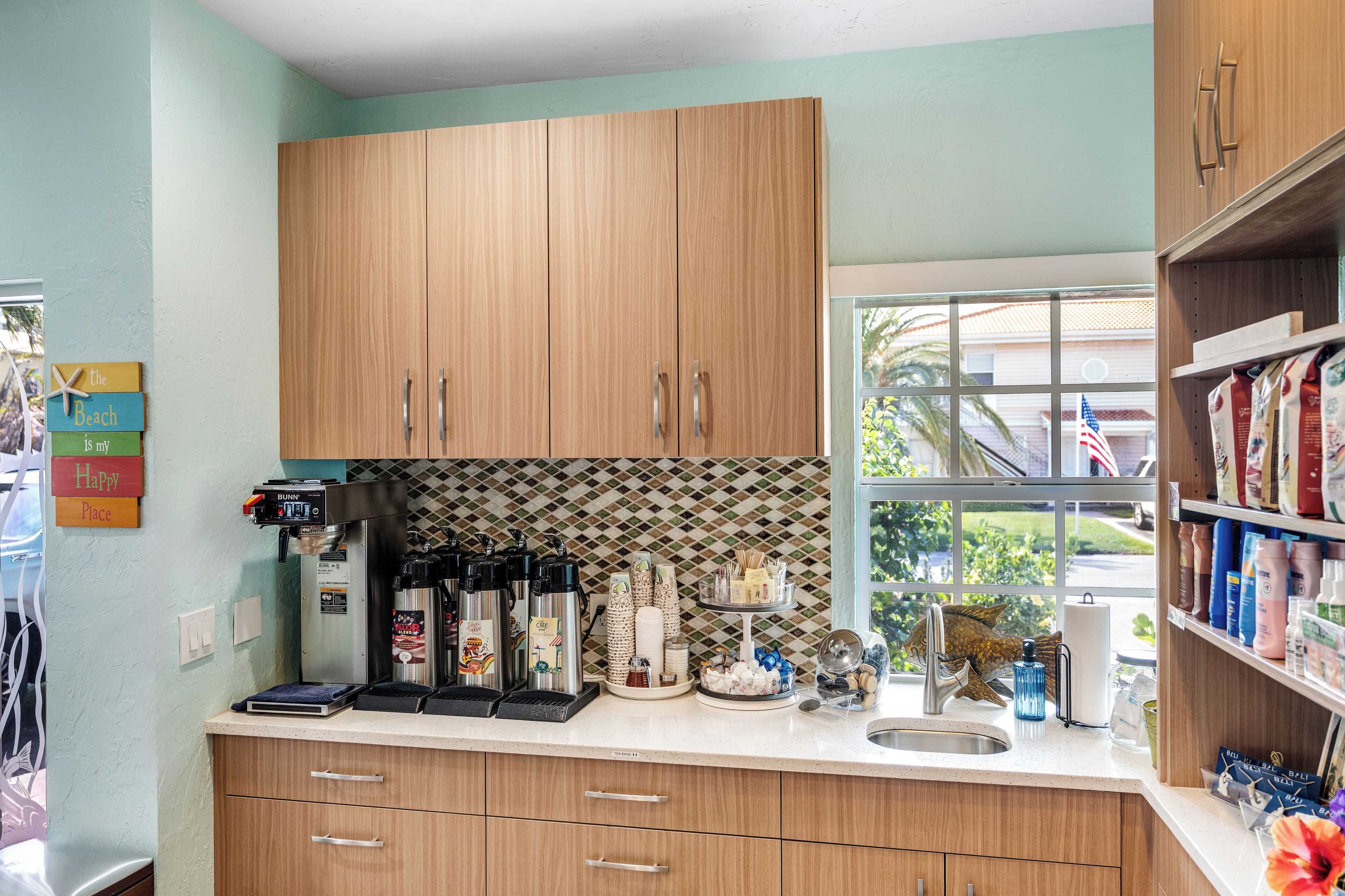 A kitchen with wooden cabinets, a coffee machine, and various kitchen items on the counter.