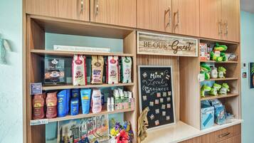 A store with wooden shelves stocked with various products, including coffee, tea, and snacks.