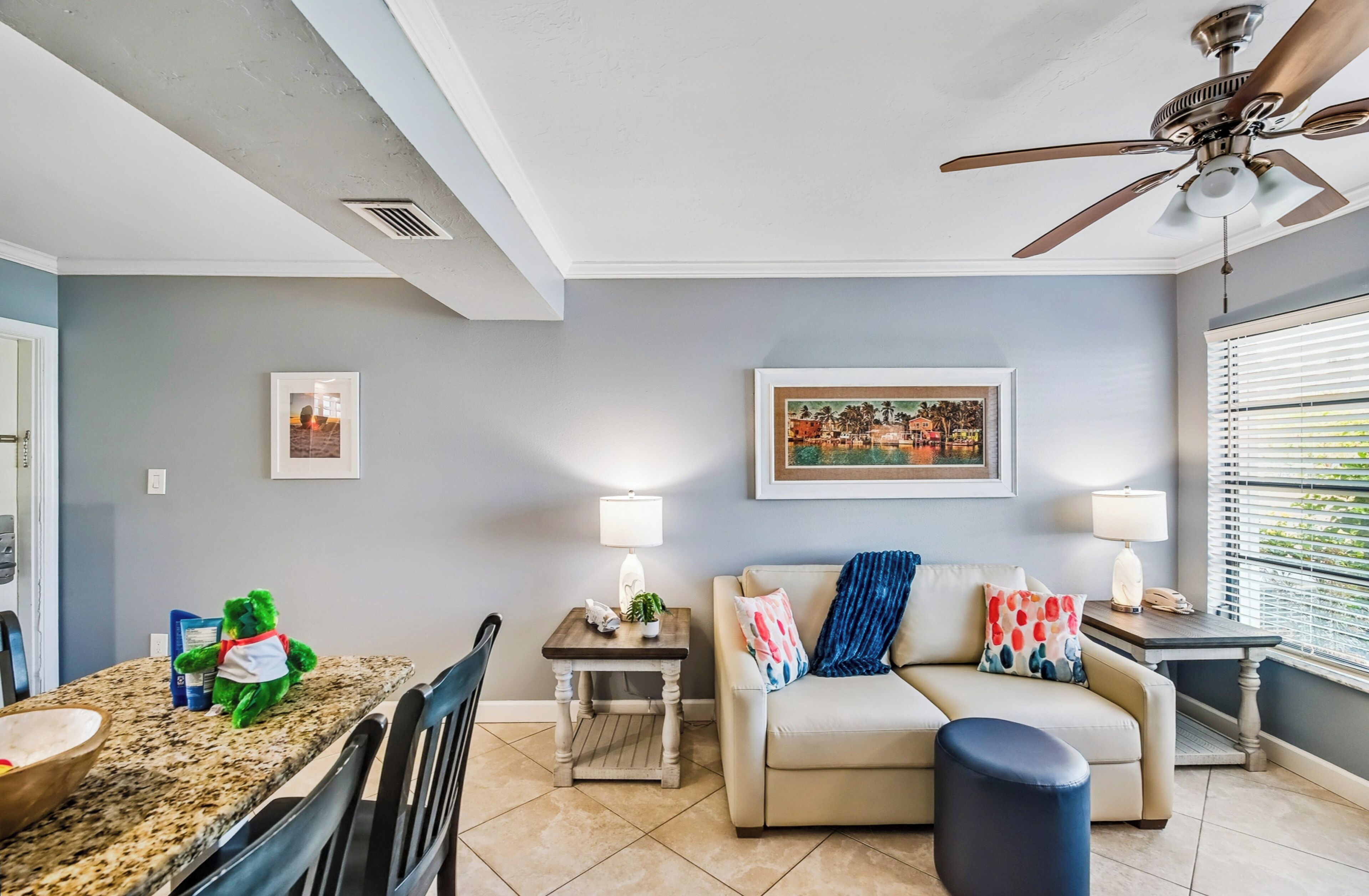 A living room with a sofa, a coffee table, and a dining area with a table and chairs.