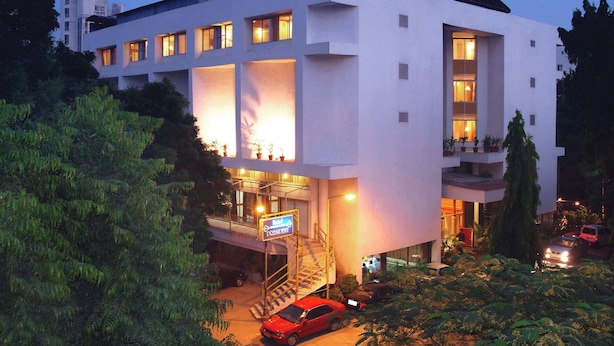 A modern hotel with a flat facade, multiple balconies, and a staircase leading to the entrance. - Comfort Inn President (Ahmedabad)
