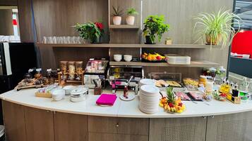 A buffet counter with various food items, condiments, and utensils.