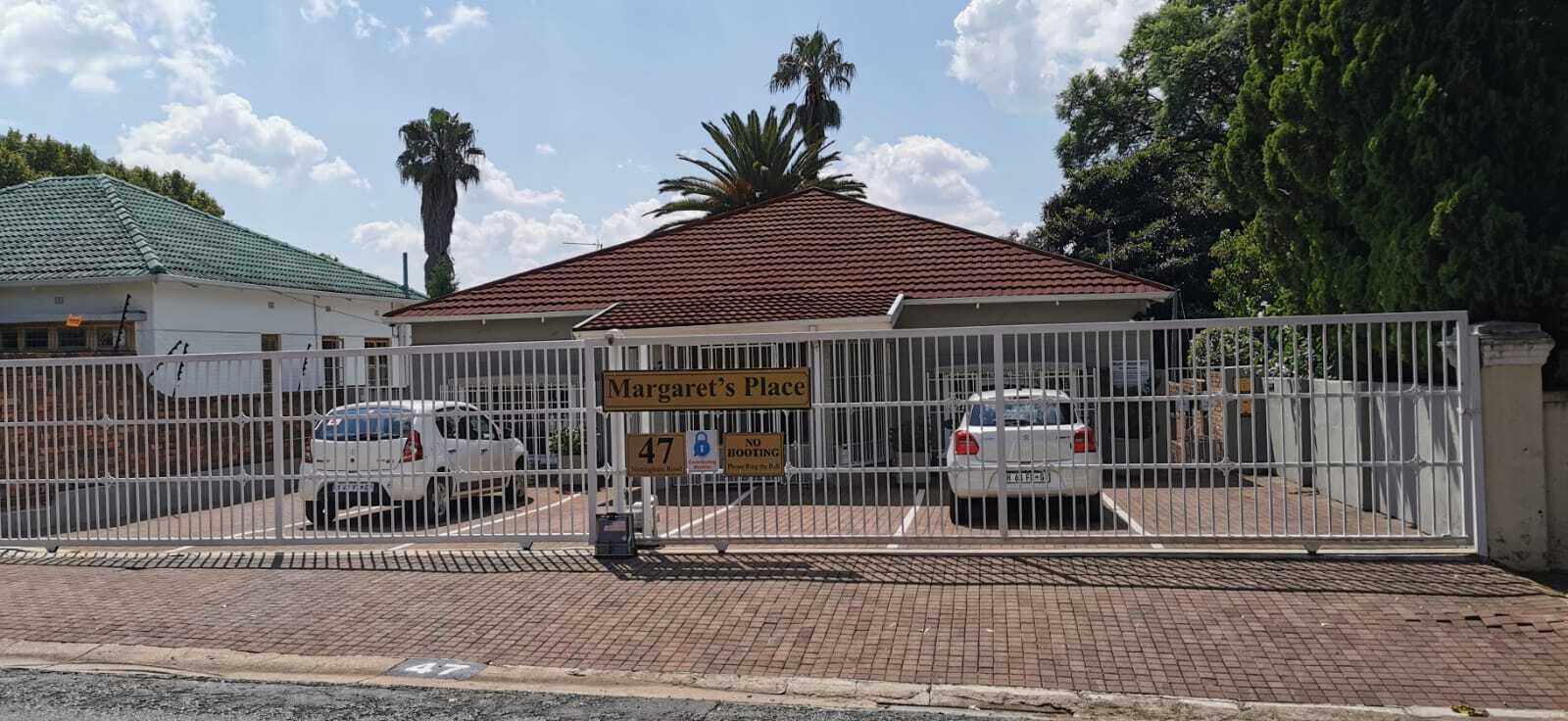 Una entrada cerrada a Margaret's Place con dos autos estacionados adentro.