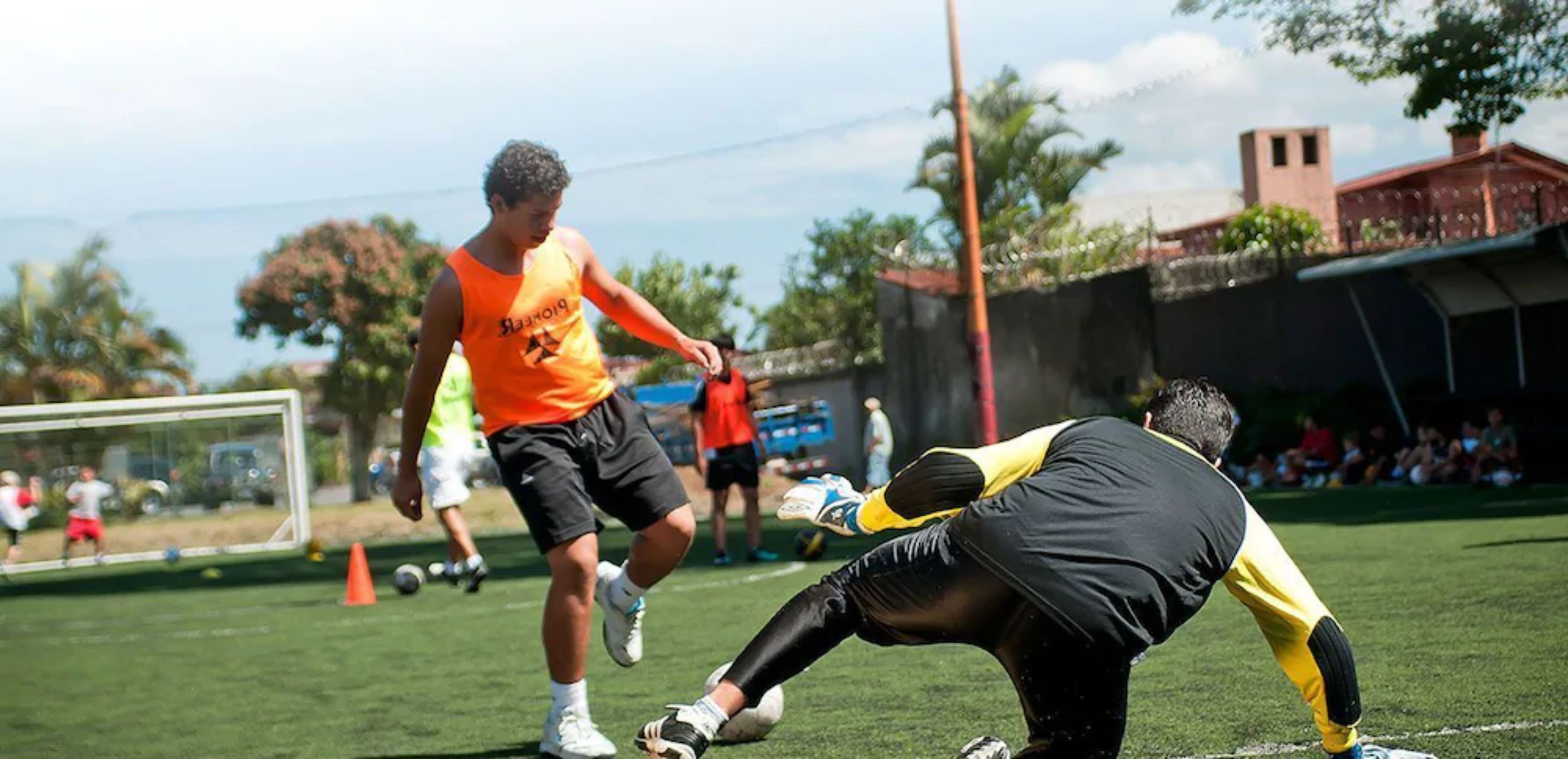 Un campo de fútbol con jugadores y un portero.