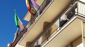 Un edificio de varios pisos con balcones, algunos con barandillas y otros sin ellas.