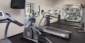 A gym with treadmills, stationary bikes, and elliptical machines.