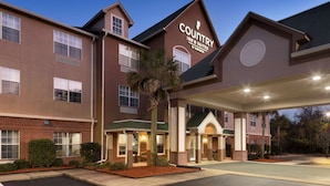 A Country Inn & Suites building with a brick facade, multiple windows, and a covered entrance area.