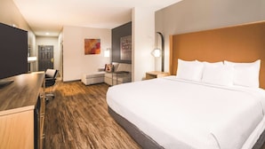Une chambre d’hôtel avec un grand lit, un bureau, une chaise et un canapé.