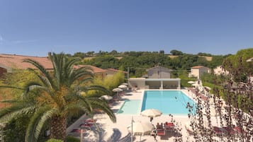 Una piscina techada, una piscina al aire libre de temporada, sombrillas