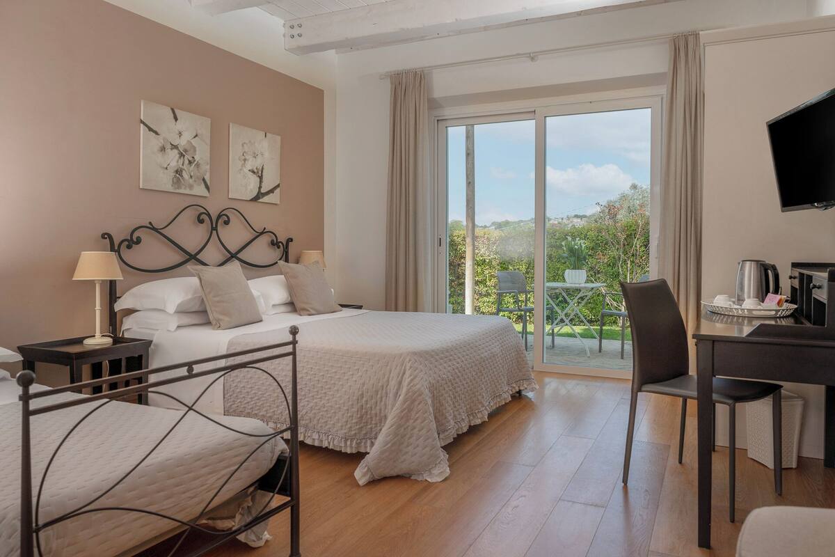 A hotel room with a bed, a desk, a chair, and a TV.