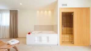 Un baño moderno con una bañera blanca, suelo de madera y un armario de madera.
