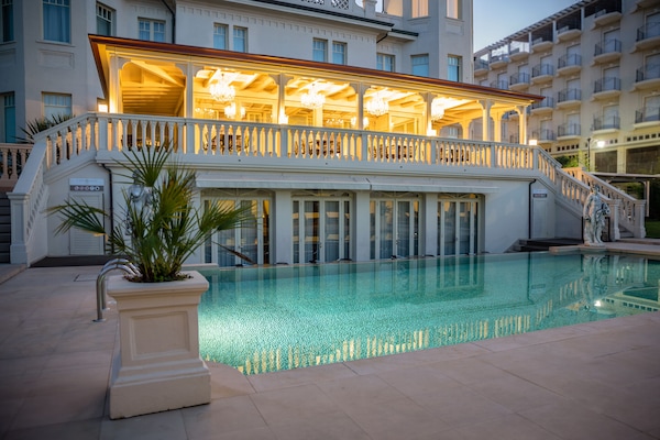 Een seizoensgebonden buitenzwembad en ligstoelen