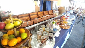A buffet setup with various food items and beverages, including fruits, pastries, and condiments. - Hotel Memory (Rimini)