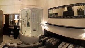 A modern bathroom with a glass-enclosed shower, a large mirror, and a cushioned bench. - Hotel Memory (Rimini)