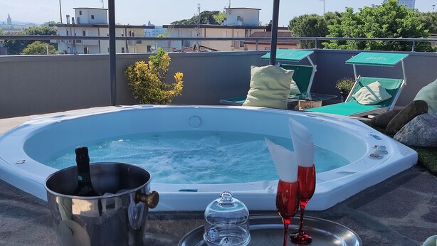 A hot tub with a bottle of champagne and glasses on a rooftop terrace. - Hotel Memory (Rimini)