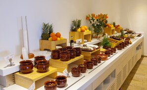 A buffet setup with various food items and serving utensils.