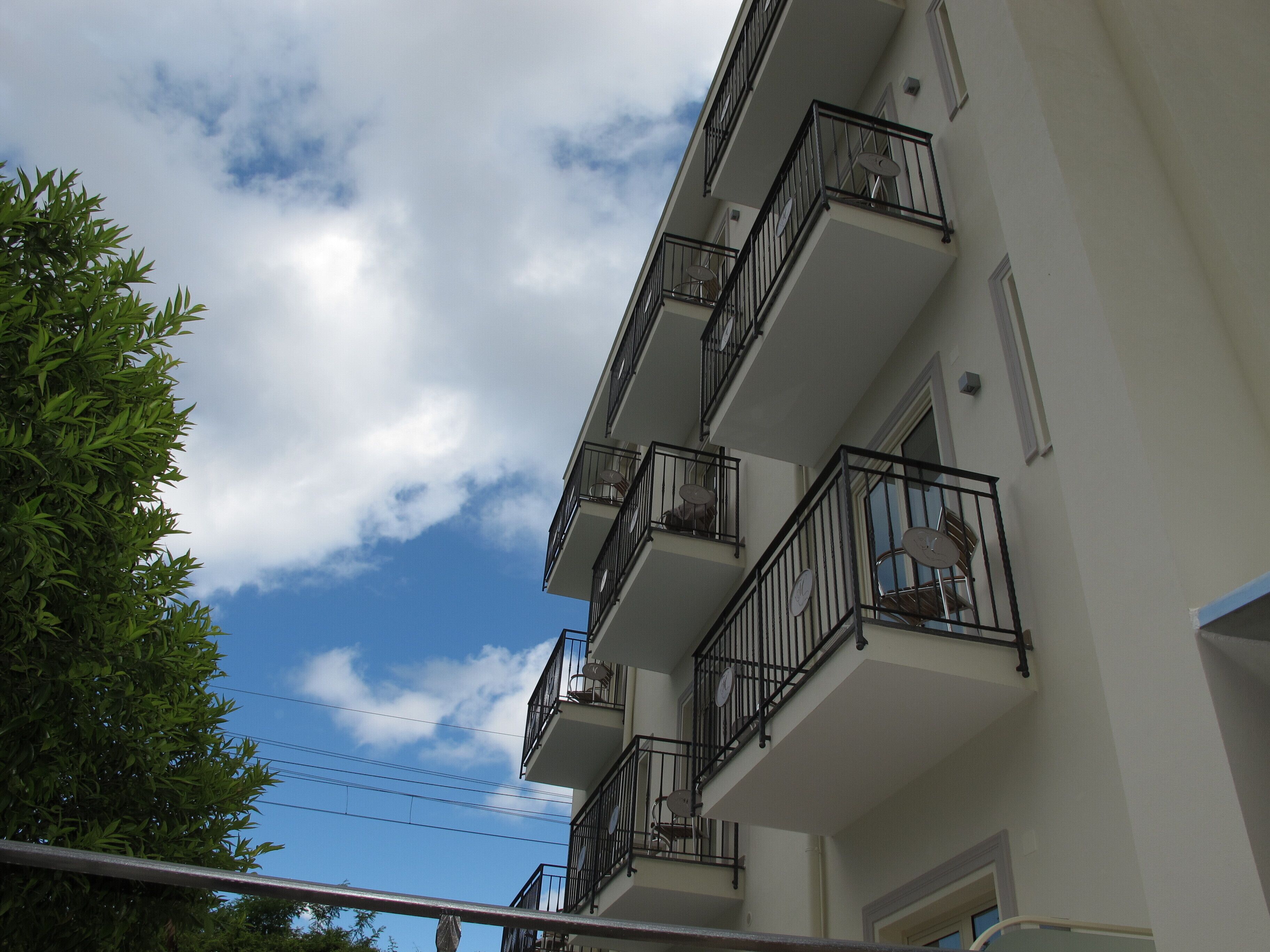 A multi-story building with balconies and satellite dishes.