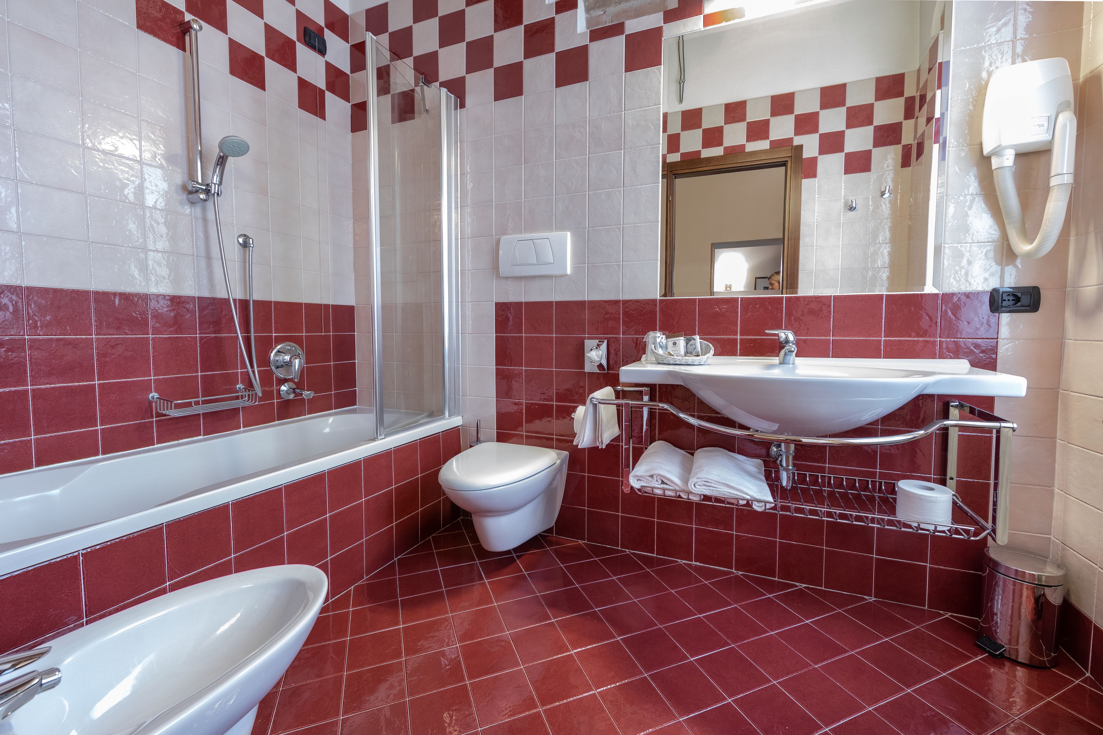 A bathroom with a shower, toilet, sink, and bathtub.