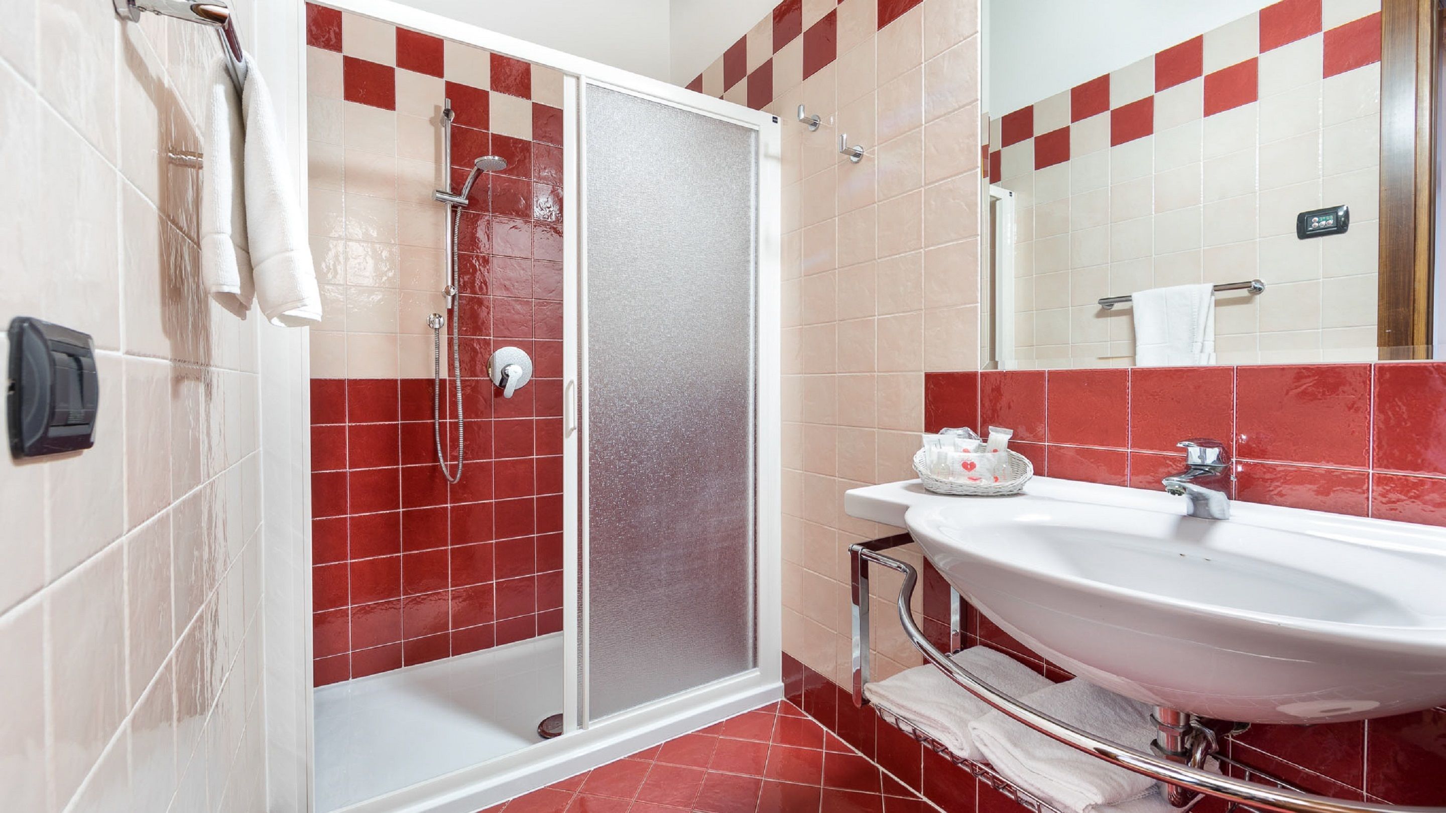 Ein Badezimmer mit Dusche, Waschbecken und Spiegel.