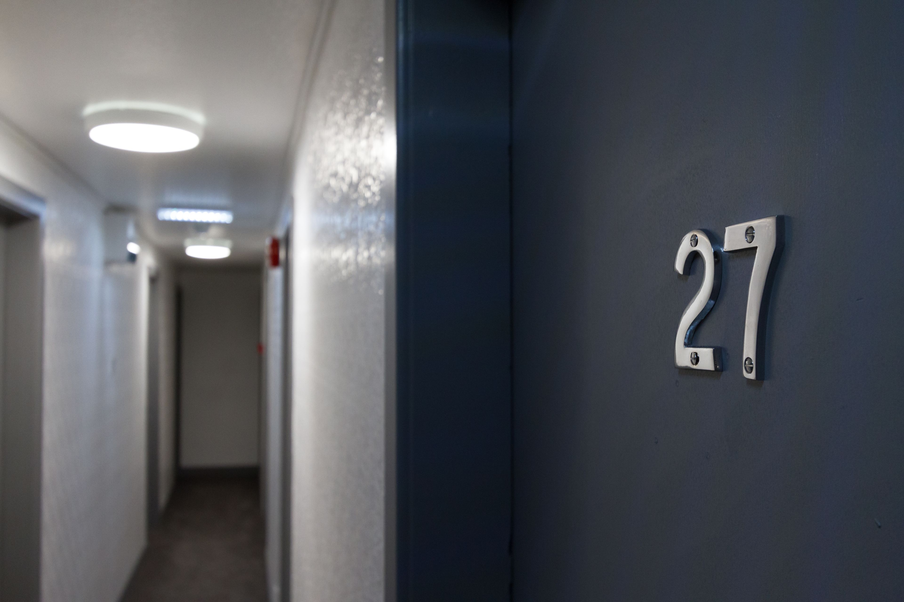 A hallway with a number '27' on the wall, indicating a room number.