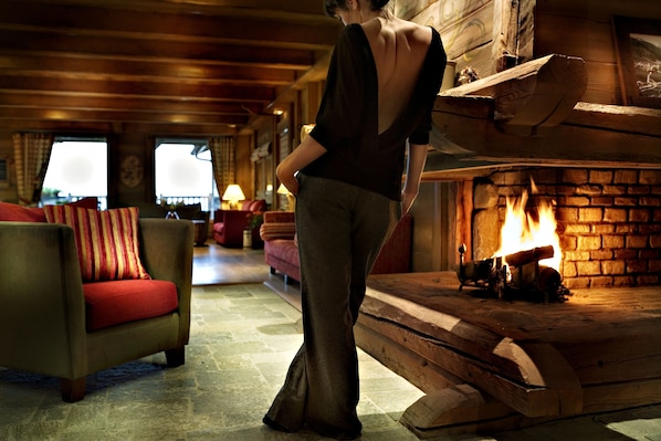 A cozy room with a fireplace, a sofa, and a chair.
