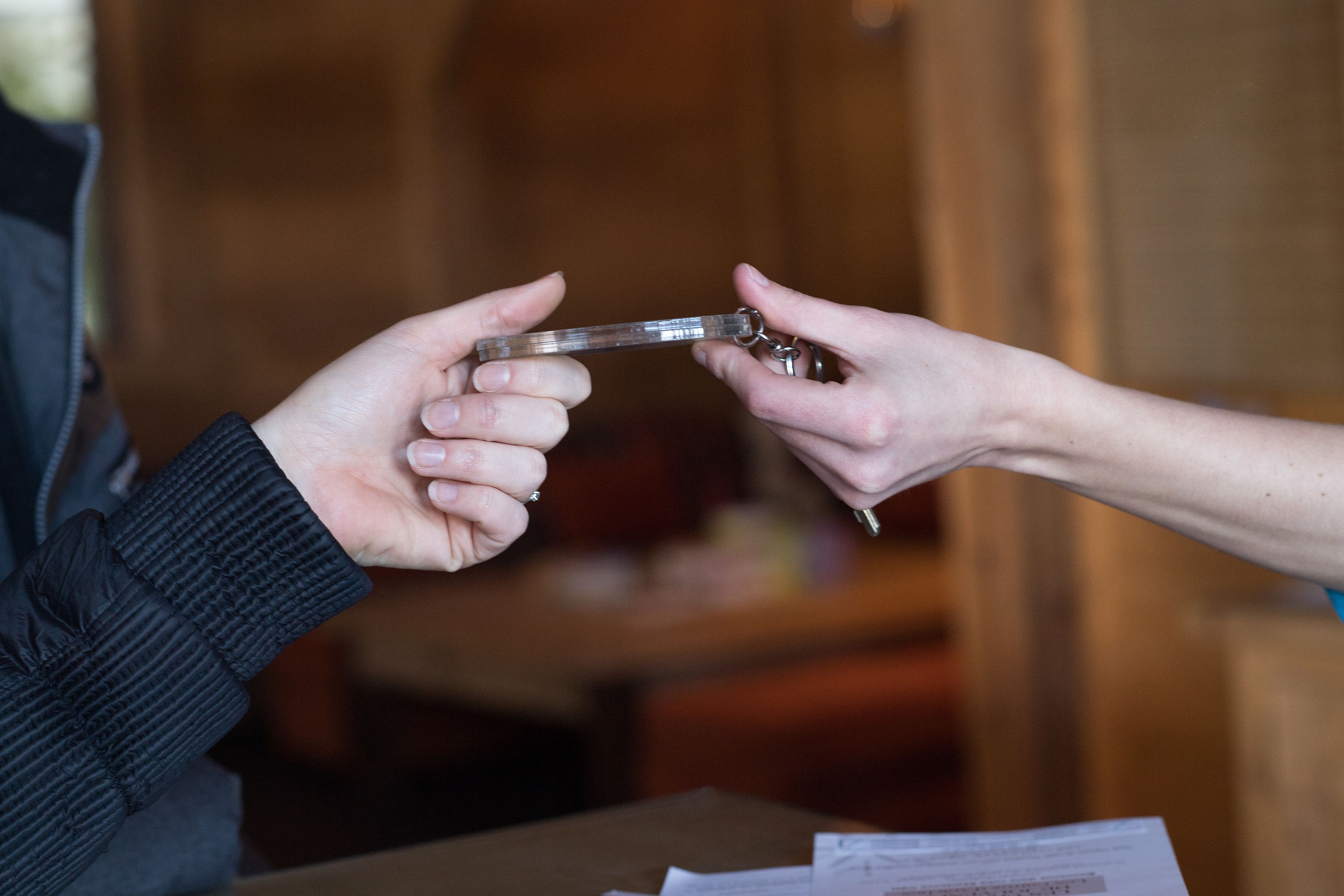 A person handing over a key to another person.