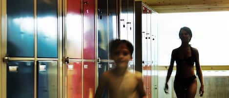 A corridor with lockers and a stone pillar.