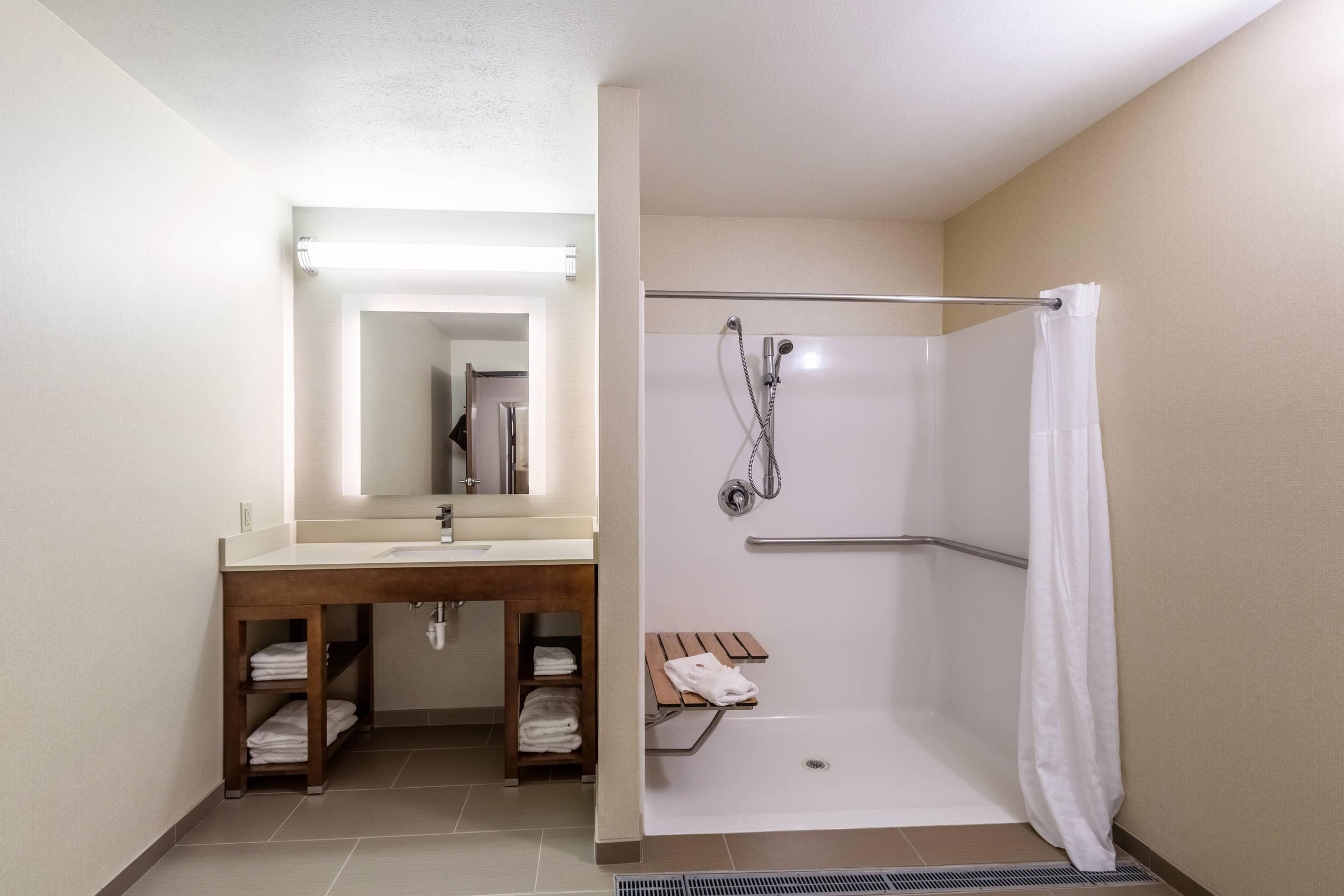Un baño con ducha, lavabo y espejo.