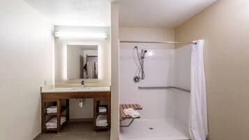 Un baño con ducha, lavabo y espejo.