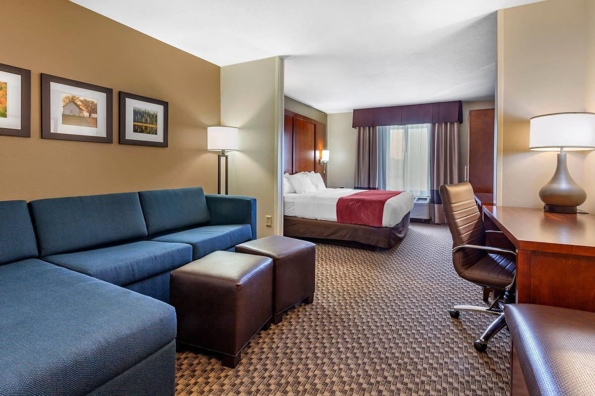 Ein Hotelzimmer mit Sofa, Bett, Schreibtisch und Lampe.