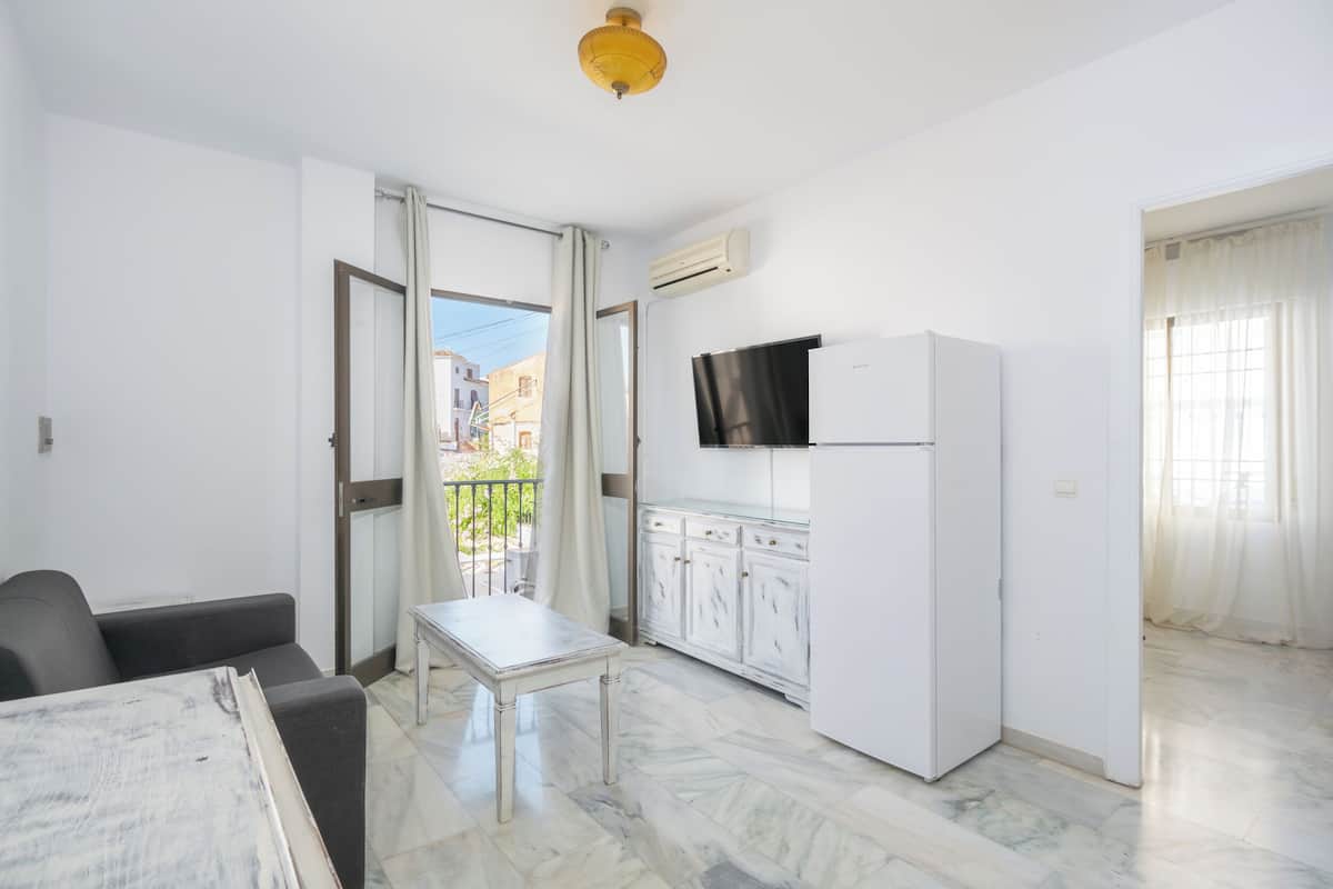 Eine moderne Wohnung mit Küche, Essbereich und einem Balkon mit Blick auf Gebäude.