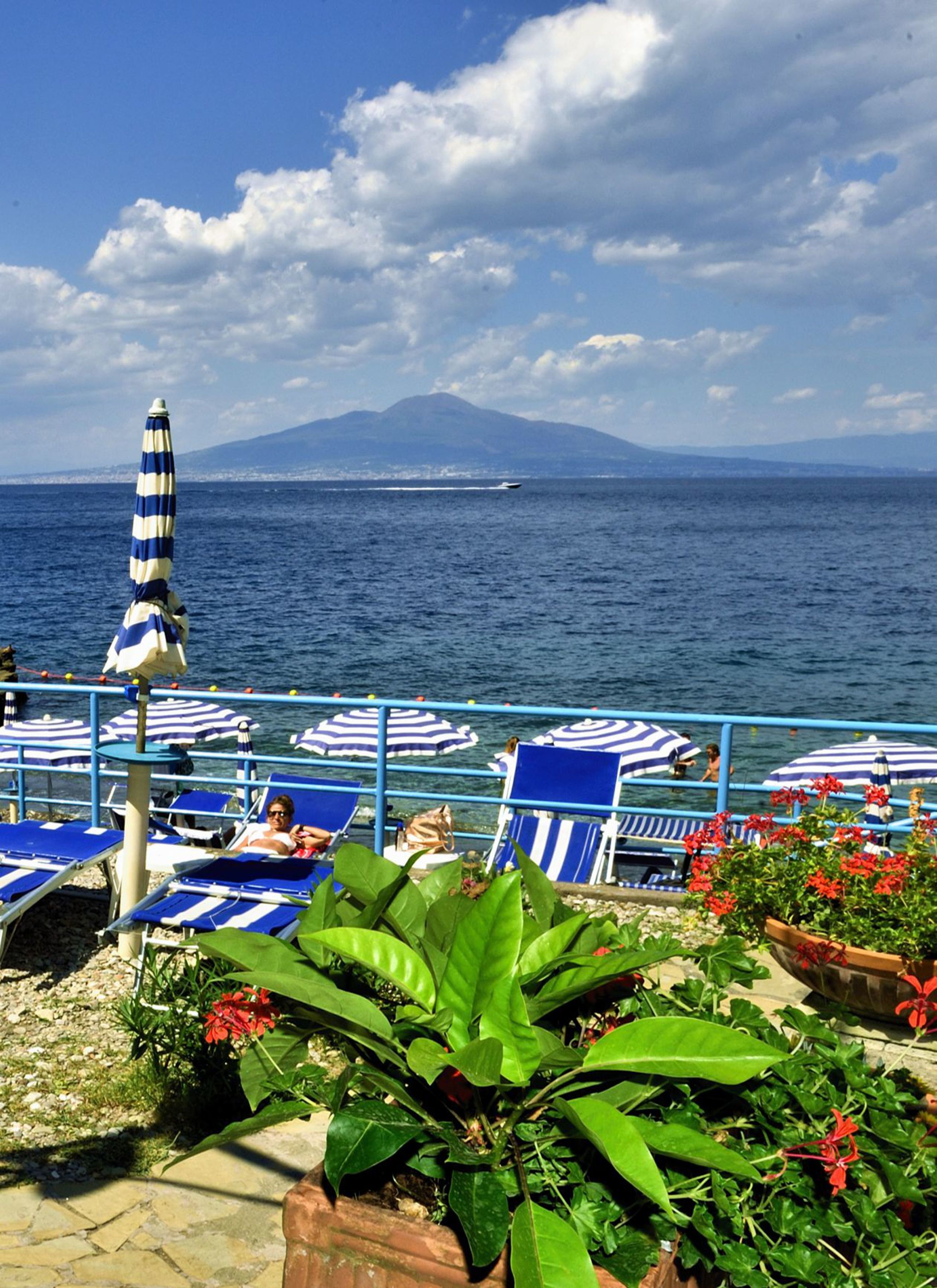 Privatstrand, schwarzer Sandstrand, Liegestühle, Sonnenschirme