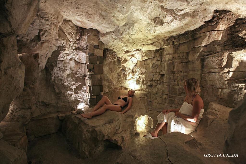 Eine Höhle mit Steinwänden und einer kleinen Öffnung, durch die Licht dringt.