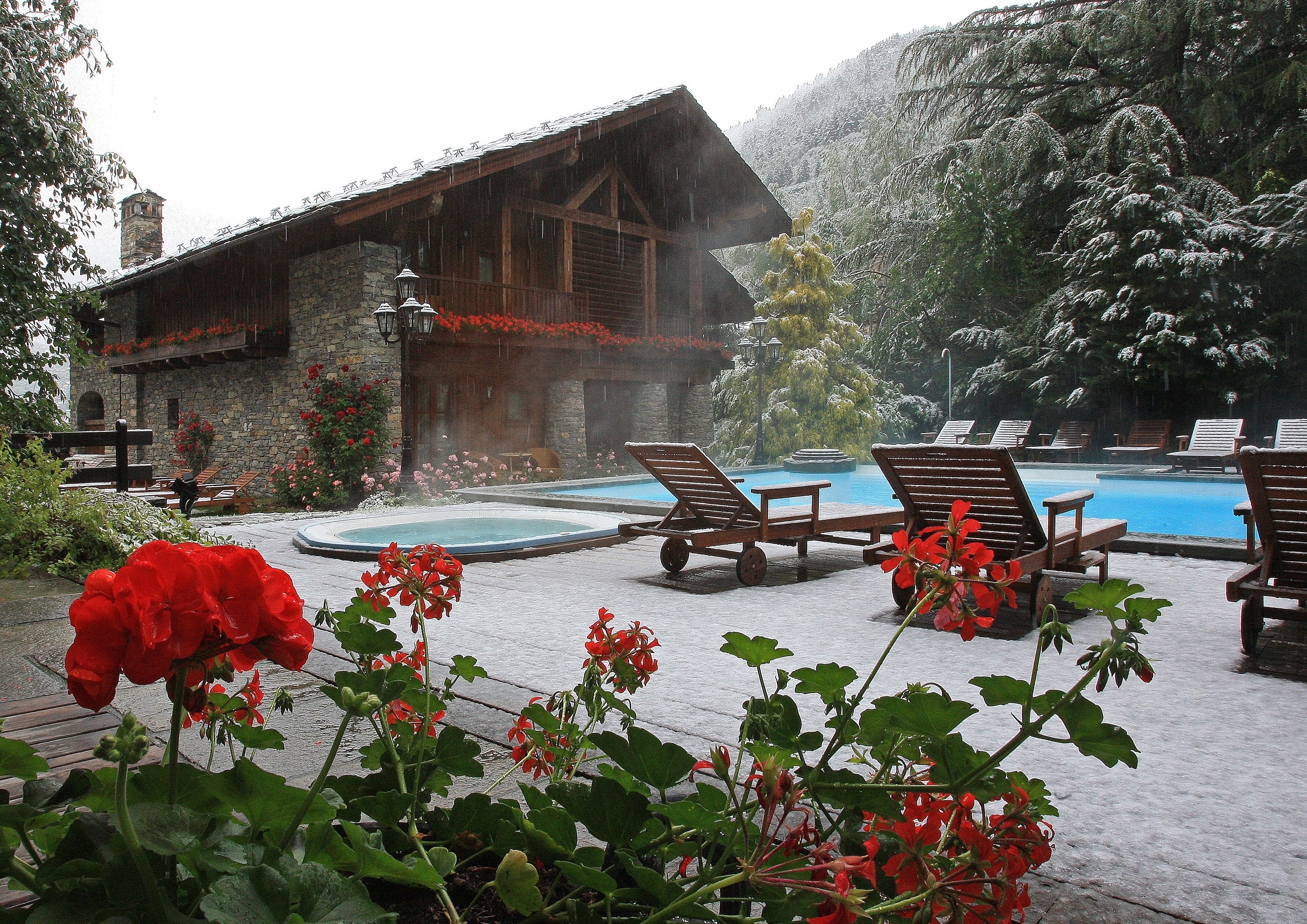 Eine Holzhütte mit Pool und Liegestühlen.