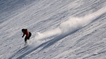 Une personne qui fait de la planche à neige sur une pente enneigée.
