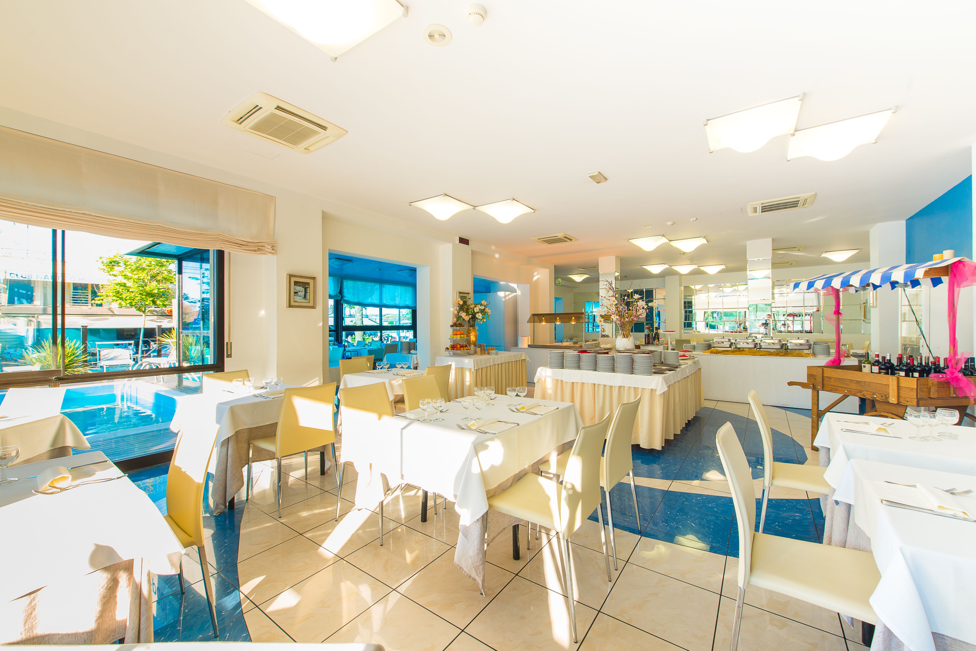 A restaurant with outdoor seating, large windows, and a buffet area.