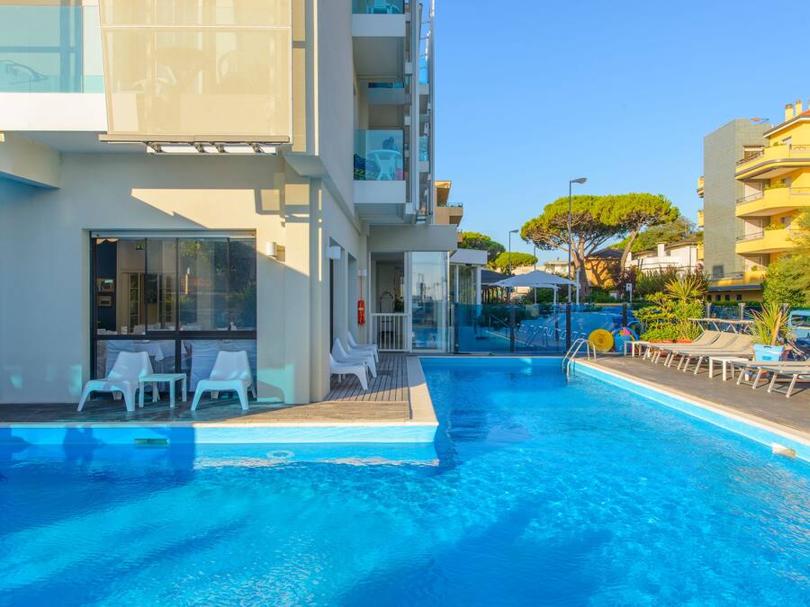 Una piscina al aire libre, sillones reclinables de piscina