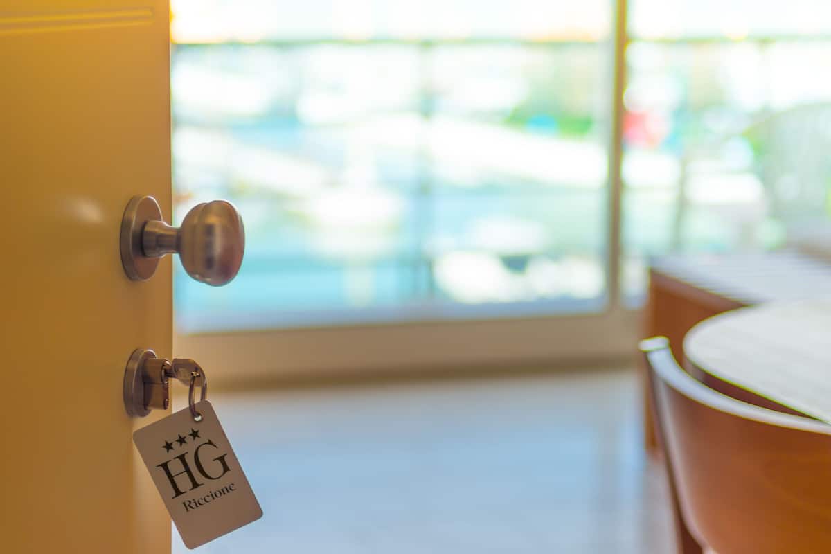 A hotel room door with a keycard labeled "HG Riccione."