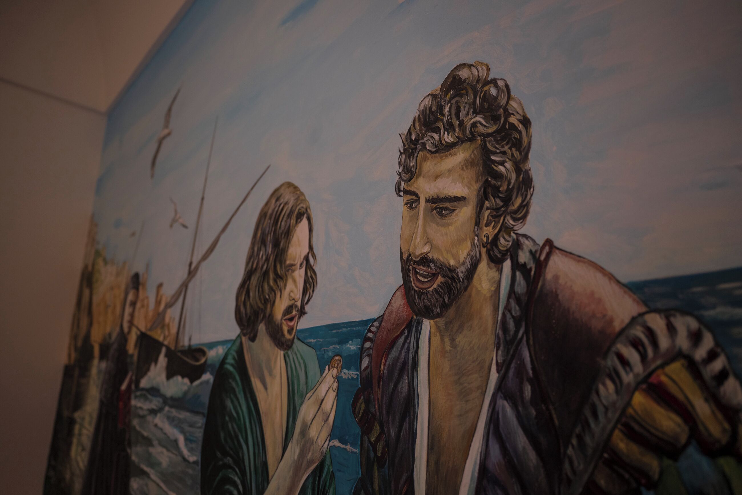 A mural with figures and a ship on a wall.