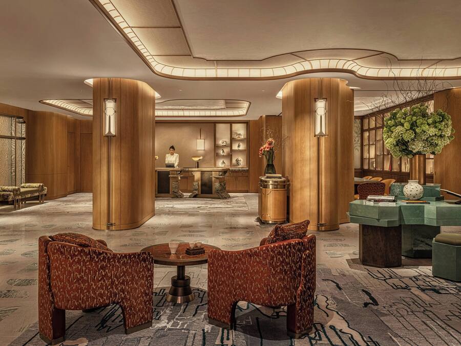 Un vestíbulo con mostrador de recepción, zona de estar y detalles decorativos.