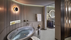 Ein modernes Badezimmer mit freistehender Badewanne, einem Waschtisch mit Spiegel und einem Handtuchhalter.