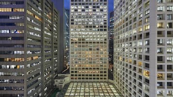 A high-rise building with multiple floors, large windows, and a central atrium with a glass ceiling.