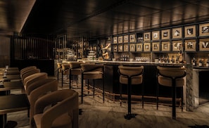 A bar area with multiple stools, a marble countertop, and framed pictures on the wall. - Mandarin Oriental The Landmark, Hong Kong (Hong Kong)