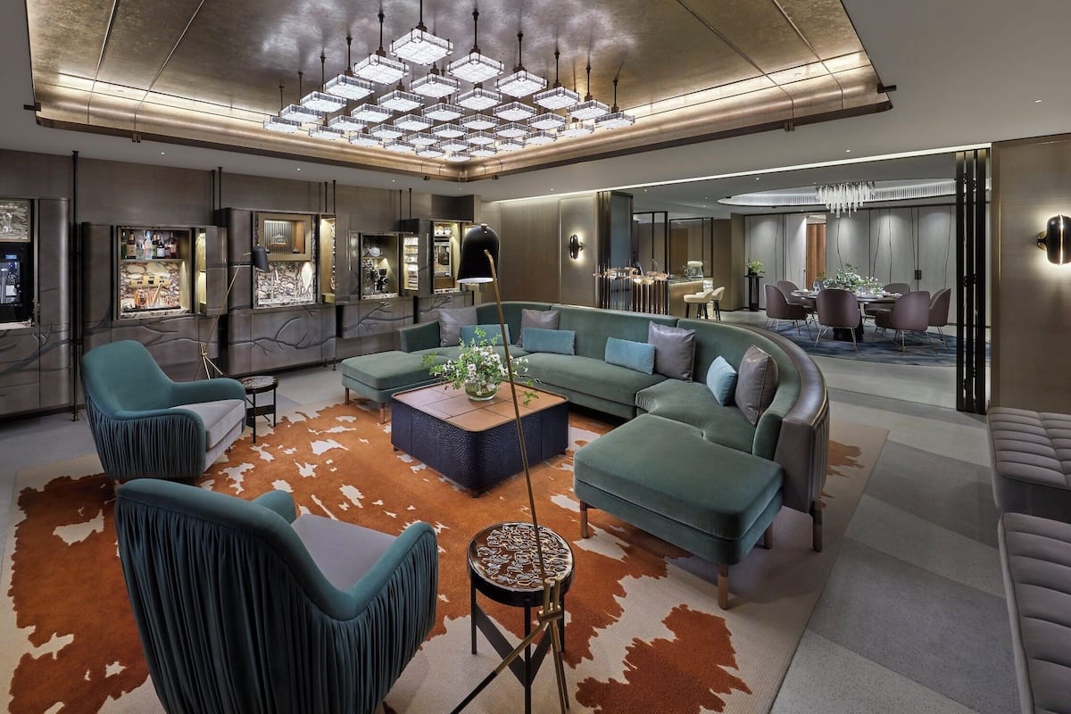 Een moderne woonkamer met een hoekbank, een bijzettafeltje en een kussen van runderleer.