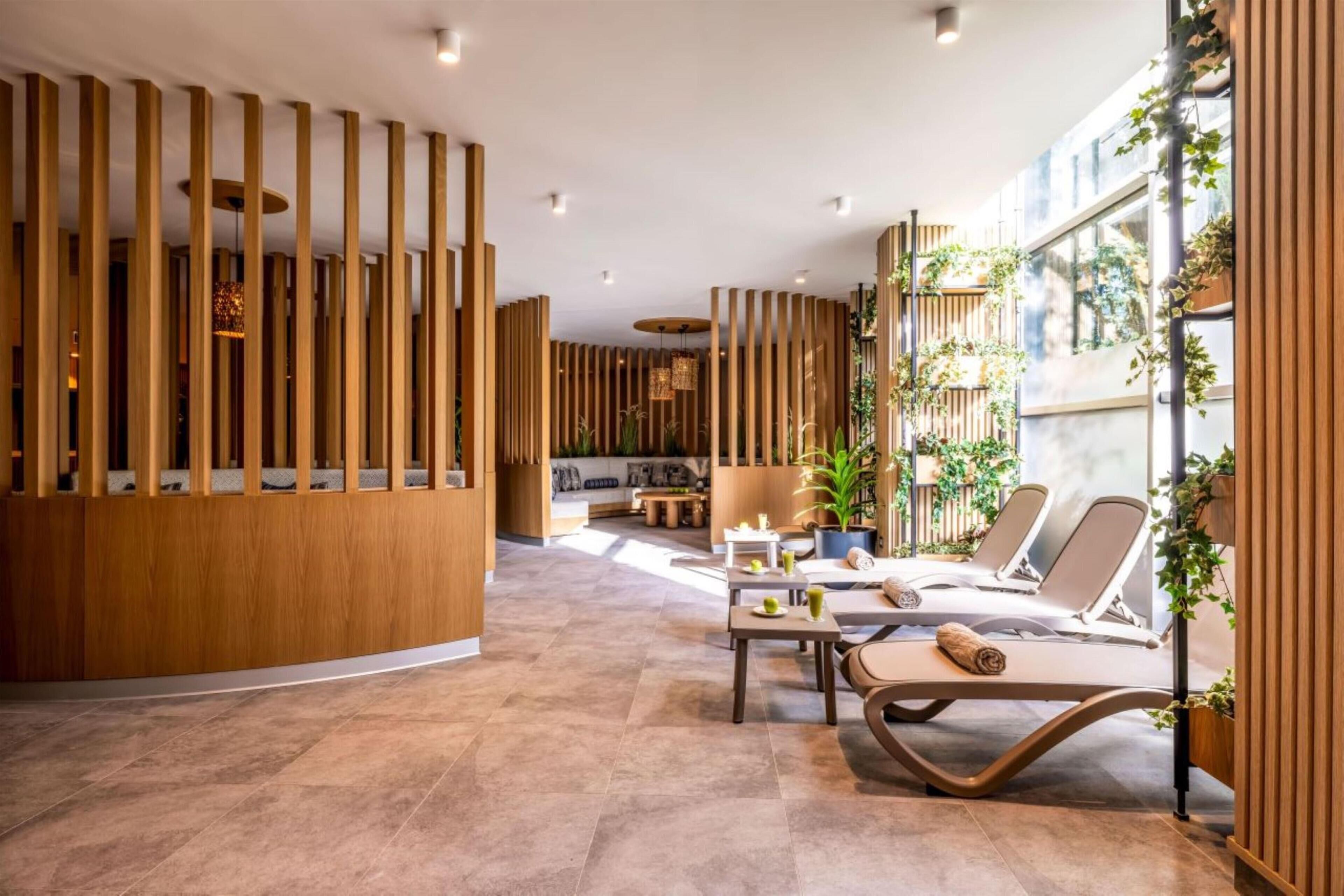 A modern spa area with a curved lounge, wooden partitions, and a view of the outdoors.