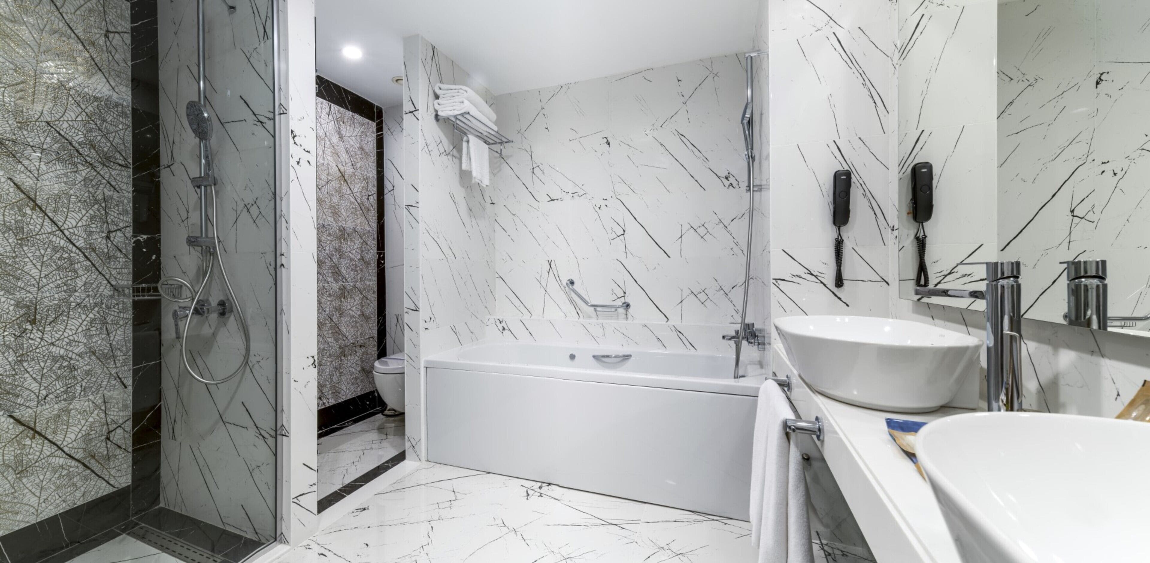 A modern bathroom with a bathtub, a toilet, and a shower area.