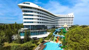 Un hotel moderno con un'architettura dalla forma unica, una piscina e uno scivolo acquatico.