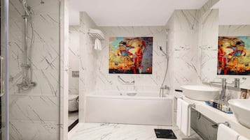 Ein modernes Badezimmer mit einer begehbaren Glasdusche, einer freistehenden Badewanne und einem Waschtisch mit großem Spiegel.